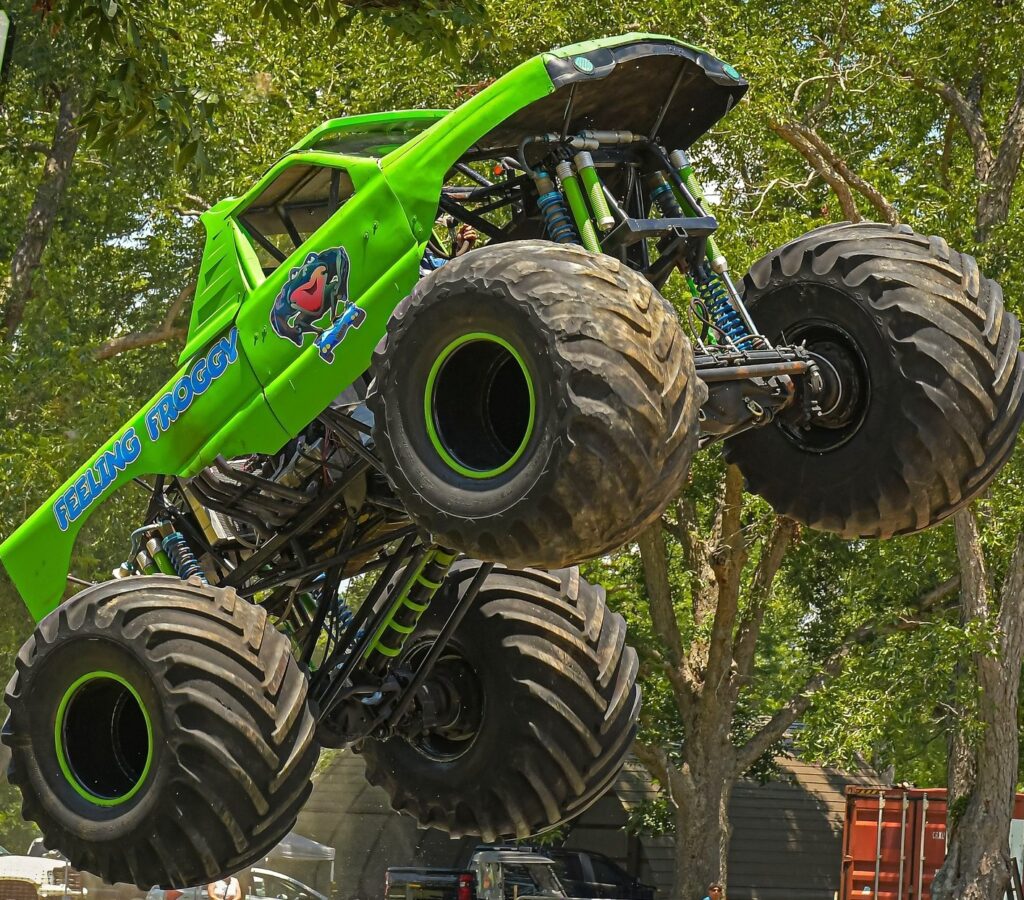 Green monster truck jumping in the air.