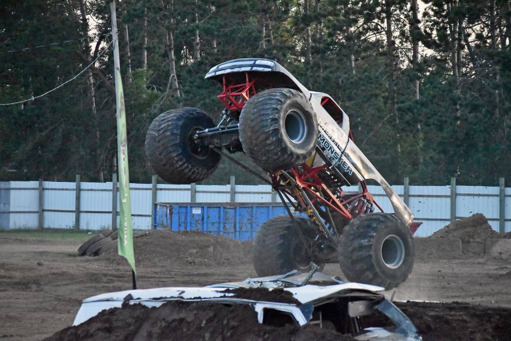 Monster truck jumping over crushed car.
